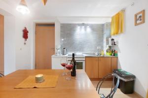 a kitchen with a wooden table with two glasses of wine at Haus am Apfelbaum in Bad Säckingen