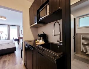 a kitchen with a sink and a counter top at Moderne Ferienwohnung mit Sonnenterrasse & Gartenblick - Strandnah und hohem Schlafkomfort in Scharbeutz