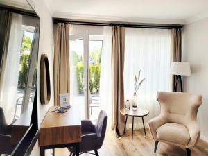 シャルボイツにあるModerne Ferienwohnung mit Sonnenterrasse & Gartenblick - Strandnah und hohem Schlafkomfortのリビングルーム(デスク、椅子付)