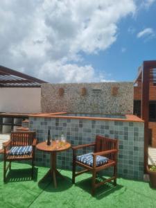 a patio with two chairs and a table at Casa Pitanga Flat in Jericoacoara