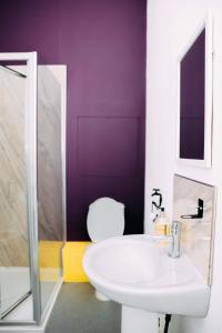a bathroom with a white sink and a purple wall at Station Hotel in Hucknall +52 photos