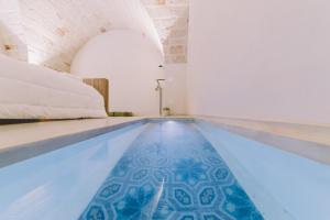 una piscina con una cama en una habitación en Cinquevite, en Polignano a Mare
