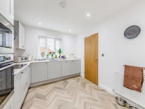 a kitchen with white cabinets and a wooden door at Sandpiper Rest - Uk46781 in Ellington