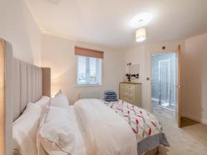 a bedroom with a bed with white sheets and a window at Sandpiper Rest - Uk46781 in Ellington