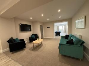 a living room with two green couches and a table at East Halton Hotel in East Halton