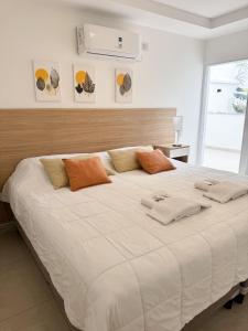 a bedroom with a large white bed with orange pillows at Casa espectacular con 3 habitaciones en suite de lujo, 4 baños, patio al aire libre con jacuzzi y ubicacion perfecta a 3 cuadras de la plaza - Bonavista Rentals in Salta