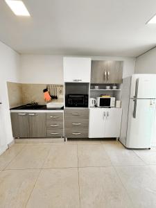 an empty kitchen with a white refrigerator and cabinets at Casa espectacular con 3 habitaciones en suite de lujo, 4 baños, patio al aire libre con jacuzzi y ubicacion perfecta a 3 cuadras de la plaza - Bonavista Rentals in Salta +9 photos