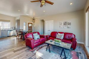 Una sala de estar con dos sofás rojos y una mesa. en Rim View 4, en Spanish Valley