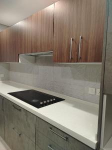 a kitchen with wooden cabinets and a stove top at The sunset resorts - منتجع ساحل الغروب in Jeddah