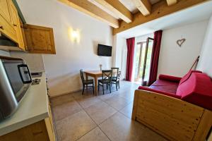 a living room with a red couch and a table at RTA Hotel Le Vallene in Terlago