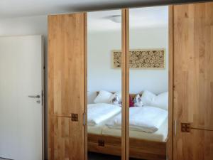 a bedroom with a mirrored door with a bed at Ferienhof Giedensbach in Oberkirch
