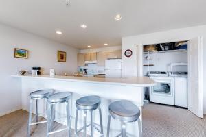 a kitchen with a counter and stools in it at Surfsong in Westport