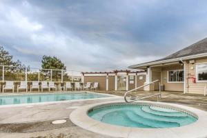 a swimming pool with chairs and a house at Surfsong in Westport