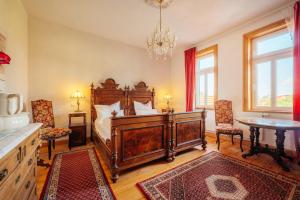 a bedroom with a large wooden bed and chairs at Unik Villa- Luxus Appartemente im Oberharz in Sankt Andreasberg