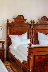 a large wooden bed with white sheets and pillows at Unik Villa- Luxus Appartemente im Oberharz in Sankt Andreasberg