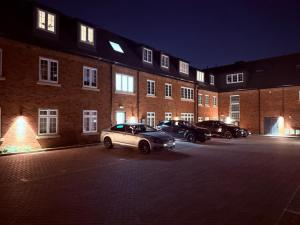a car parked in a parking lot in front of a brick building at Stylish & Spacious 3BR 3Bath with Private Parking, WiFi, Smart TVs in Spon End