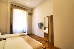Una habitación de hotel con dos camas y un espejo. en The Liman Hotel Baku, en Baku