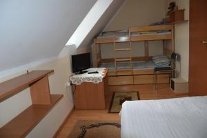 a bedroom with a bunk bed and a desk with a computer at Agroturystyka RANCZO na Mazurach in Nidzica