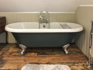 y baño con bañera y suelo de madera. en Old Rectory Loft, en Fernhurst 2 fotos más