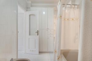 エル・メダノにあるCasa Horizonteの白いバスルーム(シャワーカーテン、バスタブ付) +16枚の写真