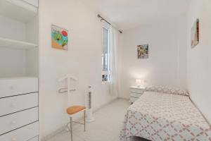 エル・メダノにあるCasa Horizonteのベッドと椅子のある白い寝室