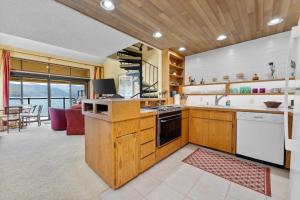 eine Küche mit Holzschränken und ein Wohnzimmer in der Unterkunft Lake Chelan Shores - Waterfront Dream 11-4 in Lakeside