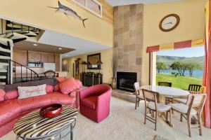 ein Wohnzimmer mit einem rosa Sofa und einem Tisch in der Unterkunft Lake Chelan Shores - Waterfront Dream 11-4 in Lakeside