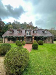 a large brick house with a green yard at Elegant Hampshire Countryside Stay in Petersfield