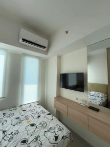 1 dormitorio con cama, espejo y TV en Osaka reverview Apartment PIK 2, en Rawalumpang