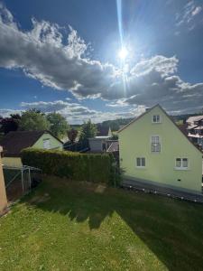 a white house with the sun in the sky at Family & Work Apartment in Schopfloch