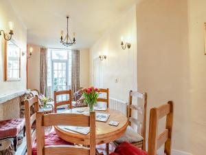 ein Esszimmer mit einem Holztisch und Stühlen in der Unterkunft Harvey Cottage in Colyton
