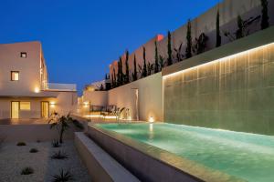 a house with a swimming pool at night at Majo Luxury Villas Panoramic Sea View Retreat with Heated Private Pools & Gym & Sauna in Agia Pelagia