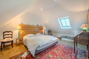 a bedroom with a large bed with a wooden headboard at Kergus - A 15 min de Morlaix in Plourin