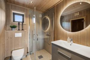 a bathroom with a shower and a toilet and a sink at Sentralt plassert hytte, alt i gangavstand in Flå +9 photos