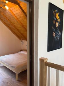 ein Schlafzimmer mit einem Bett und einem Gemälde an der Wand in der Unterkunft Cabana MBM in Baia Sprie