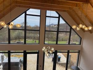 a large room with large windows and a chandelier at Cabana MBM in Baia-Sprie