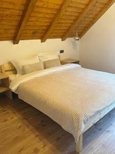 ein großes Bett in einem Zimmer mit Holzdecken in der Unterkunft Cabana MBM in Baia Sprie + 22 Fotos