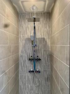 a shower with a shower head in a bathroom at Chambre d'hôtes rénovée du XVIII ème in Saint-Aubin-la-Plaine