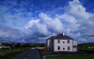 a white house on the side of a road at Doolin House in Doolin