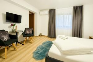 コリビツァにあるCazare Colibița Casa Lipan cu jacuzzi, foișor și loc de joacăのベッドとテーブルと椅子のあるホテルの部屋