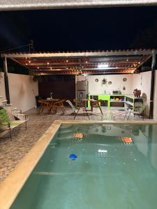 a swimming pool in a house with a table and chairs at Departamentos misavi in Pisté +1 photo