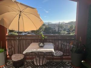 a table and chairs with an umbrella on a balcony at Cozy Studio in Cannes in Le Cannet
