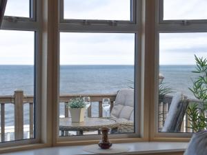 a view of the ocean from a room with windows at Sunset Lodge in Llanddulas