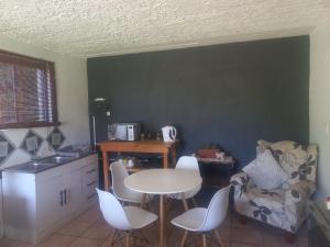 une cuisine avec une table et des chaises et une table et une chaise dans l'établissement Ormonde guesthouse, à Pretoria