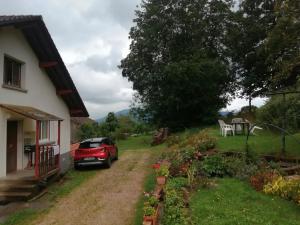 CleurieにあるAppartement confortable à Cleurie avec jardinの家の前に停車した赤い車 +3枚の写真