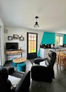 sala de estar con mesa y sillas de cuero negro en Ti'Belot - calme près de la mer, en LʼAiguillon-sur-Mer