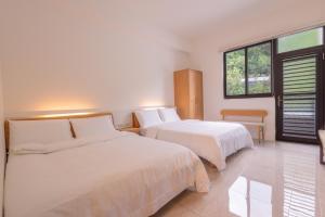 a bedroom with two beds and a window at 大武民宿2195 in Shang-wu +8 photos