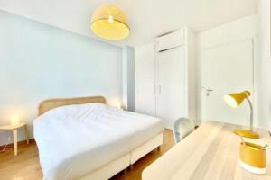 a bedroom with a bed and a table with a lamp at Art Deco I Center I High-Speed Wi-Fi I Bright in Saint-Nazaire