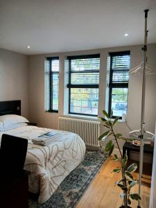 a bedroom with a bed and some windows at Amara & Nomad 1 in London