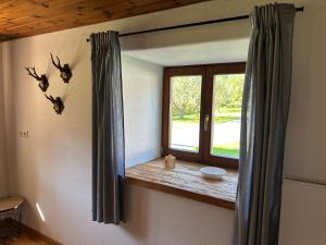 a room with a window with birds on the wall at Ferienwohnung Beim Straßer in Flintsbach